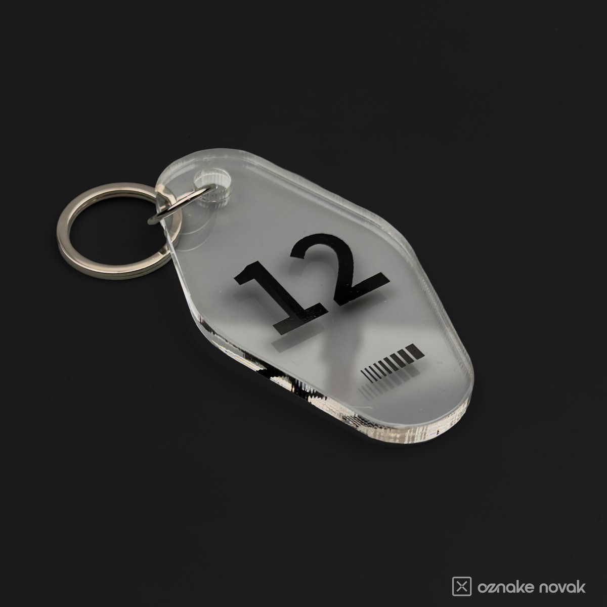 Clear acrylic key tag with black number 12 and Fina GS logo on a metal key ring