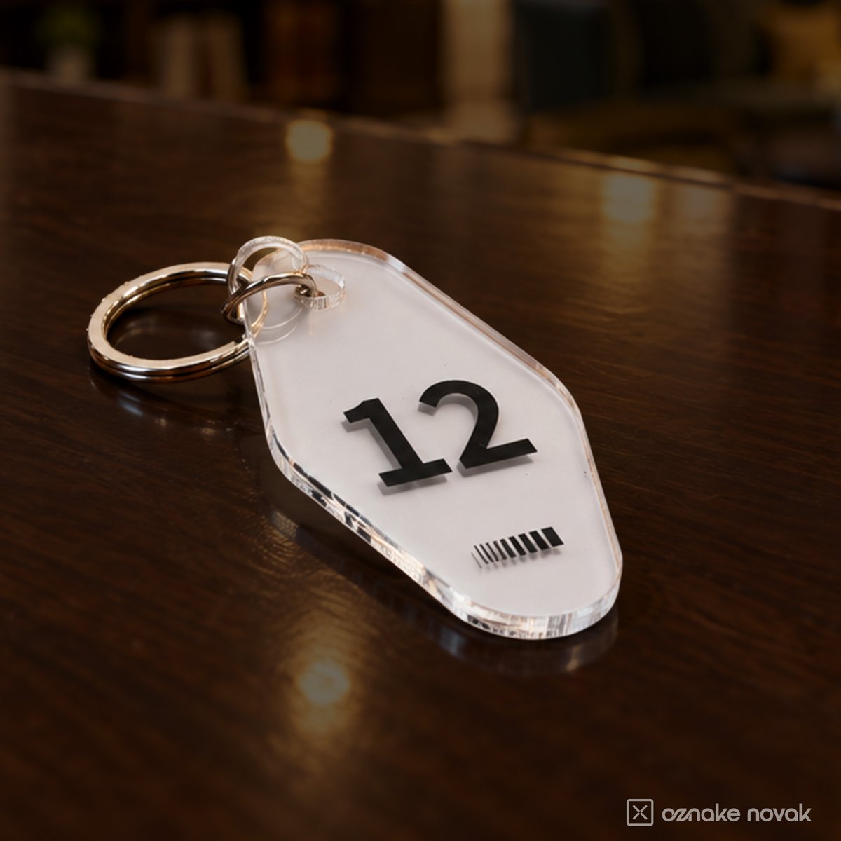 Clear acrylic key tag number 12 lying on a wooden desk
