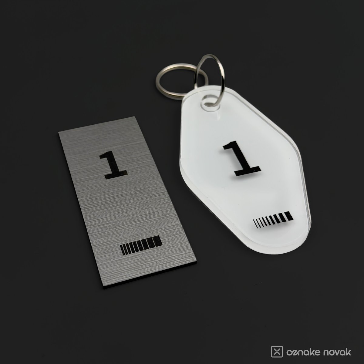 Brushed metal name plate and opal white key tag, both numbered 1, side by side