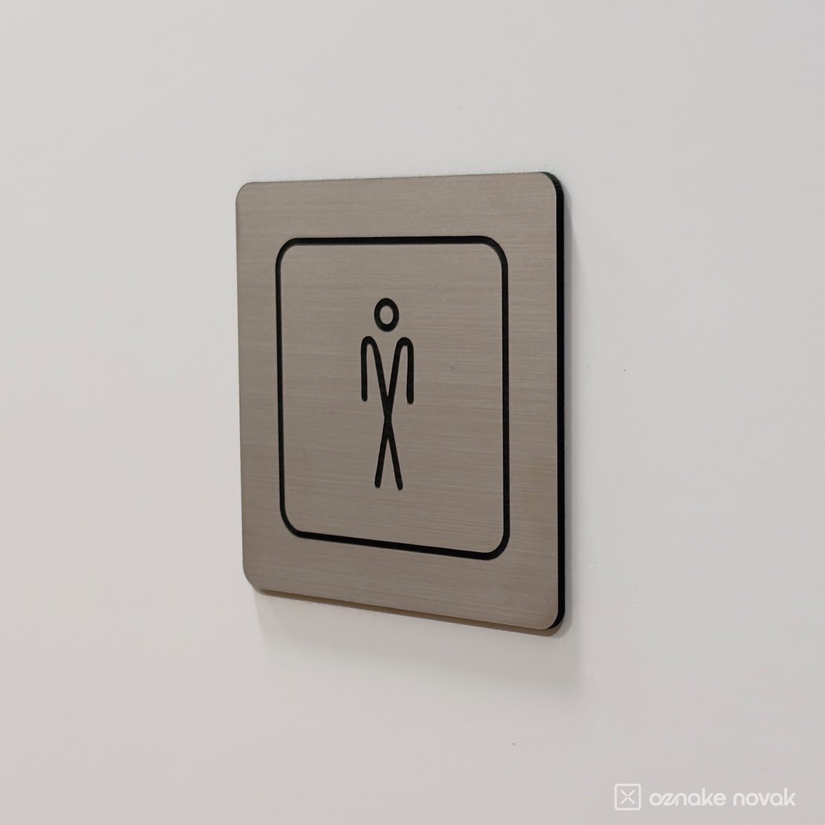 Men's restroom sign mounted on a light wall, side view